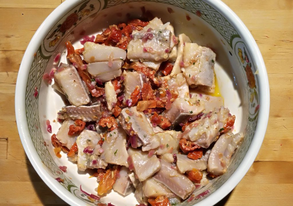 Schüssel Matjes-Salat mediterran mit Tomaten und Zwiebeln