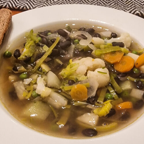 Gemüsesuppe mit schwarzen Bohnen serviert